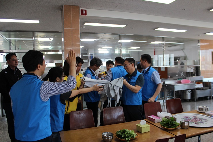 전남개발공사 직원들이 복지관 식당에서 앞치마를 나눠가지고 있는 모습