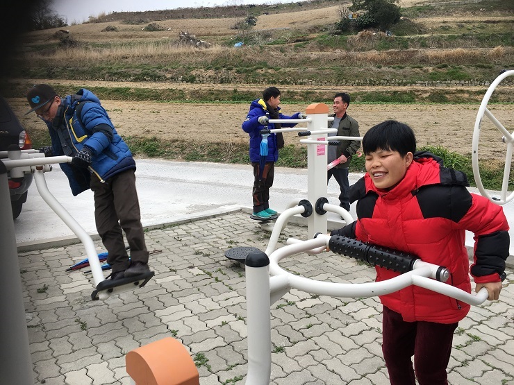 공원 산책 중 운동기구를 사용하고 있는 이용인의 모습