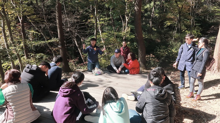 숲 오감체험활동에 대해 설명을 듣고 있는 가족들의 모습