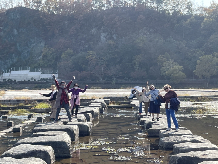 사진설명입니다. 강진만생태공원의 돌다리를 건너고 있는 자원봉사자들의 모습입니다.