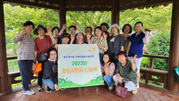 2023년 활동지원사 나들이 현수막을 들고 활동지원사들이 다함께 찍은 단체사진입니다. 
