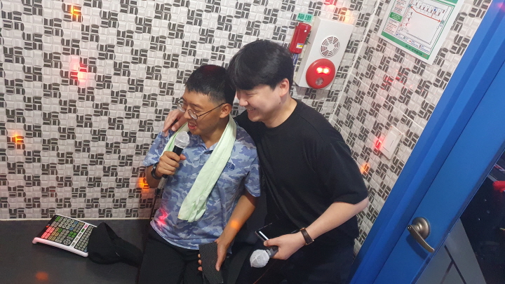 오락실 노래방에서 즐겁게 노래를 부르고 있는 당사자와 옹호인의 사진입니다. 