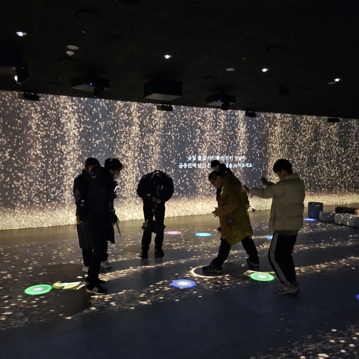 국립나주박물관을 관람하던 중, 불빛 체험관에서 바닥의 빛을 밟는 체험을 하고 있는 모습입니다. 