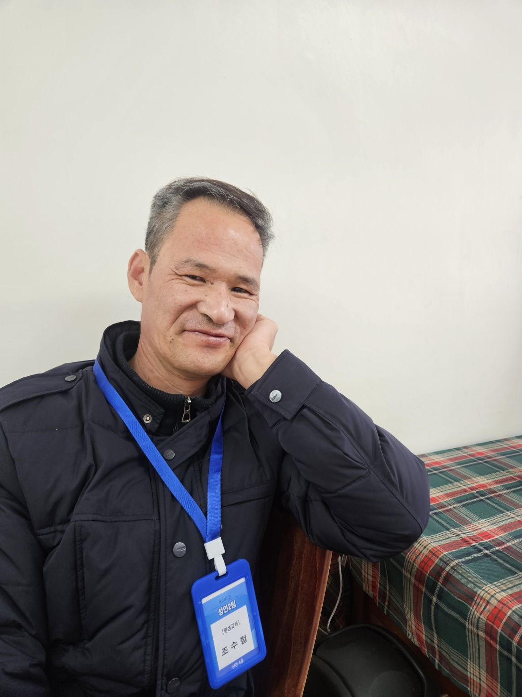 컷트 후 스타일링을 마친 남성이용인이 만족한 듯 웃는 표정으로 찍은 사진입니다. 