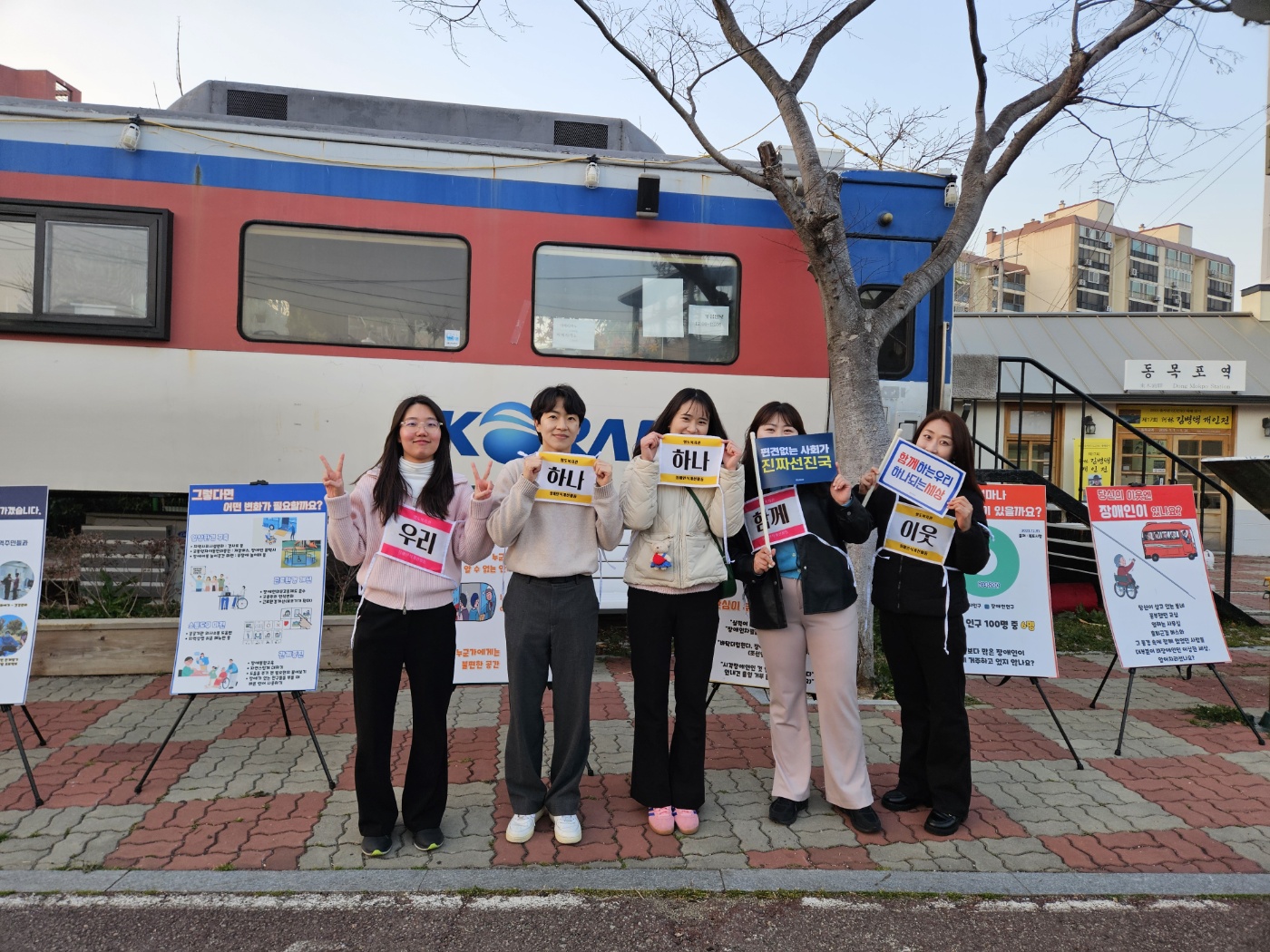 지역주민들이 장애인식개선 메세지를 담은 조끼를 입고 깃발을 든 채로 함께 찍은 사진입니다. 