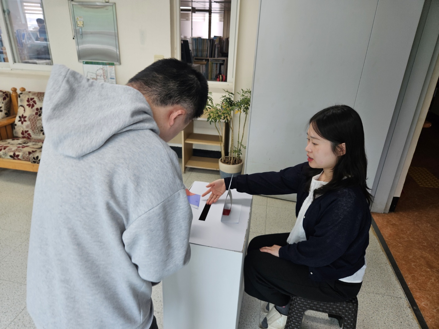 투표를 완료한 뒤, 투표함에 투표용지를 넣고 있는 이용인의 모습입니다. 