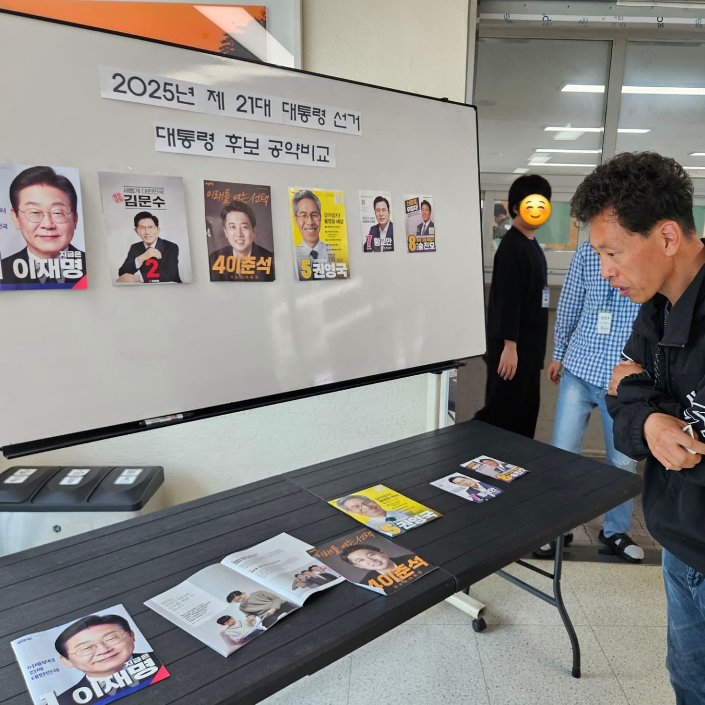후보들의 공보물을 보며 고민하고 있는 이용인의 모습입니다.