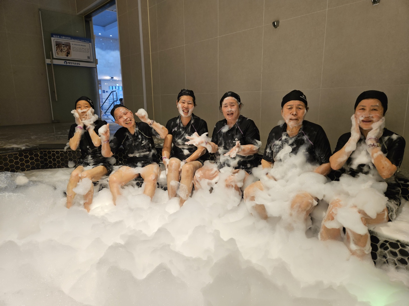 몸과 얼굴에 거품을 뭍힌 여섯명의 자원봉사자들이 함께 찍은 기념사진입니다.