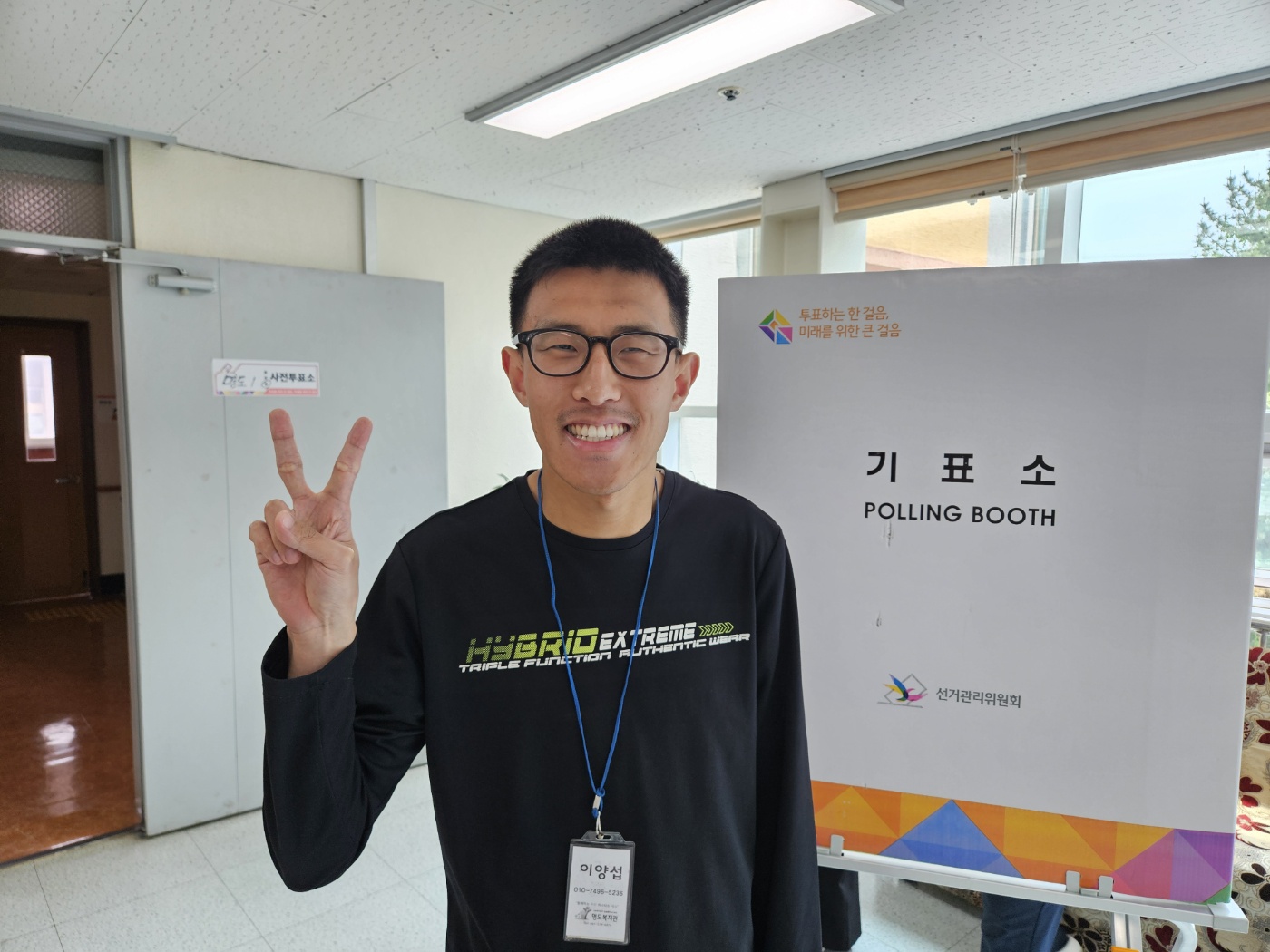 기표소 앞에서 활짝 웃는 표정과 브이포즈를 취하고 촬영한 이용인의 사진입니다.