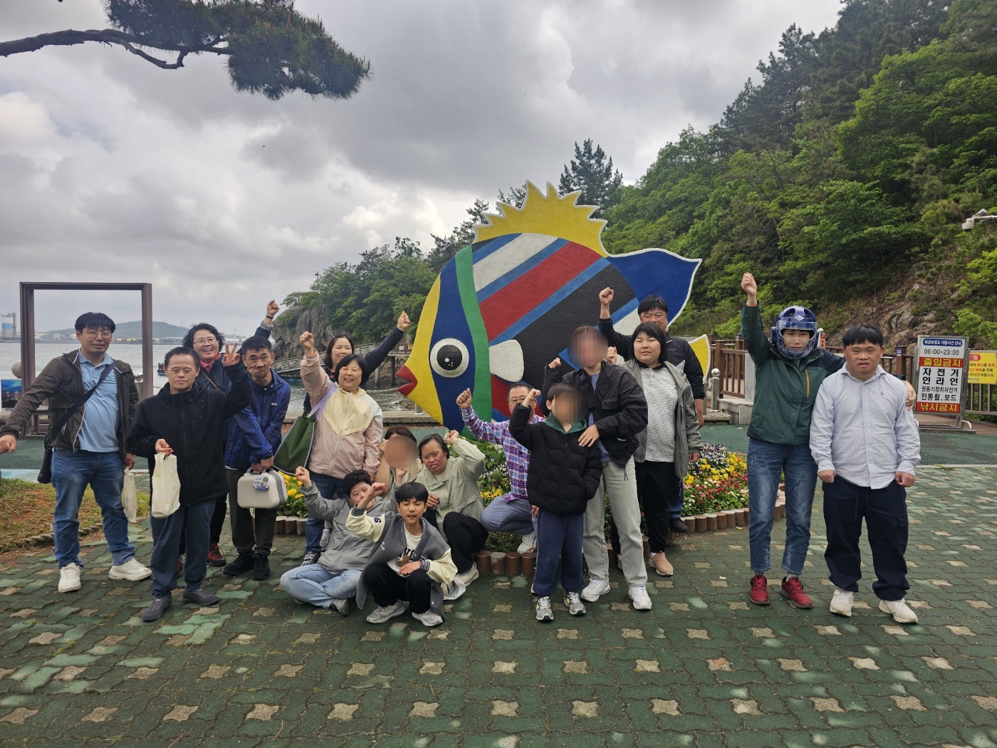갓바위 근처 물고기 조형물 앞에서 야유회를 함께한 자원봉사자들과 이용인, 담당교사가 모두 함께 찍은 단체사진입니다. 