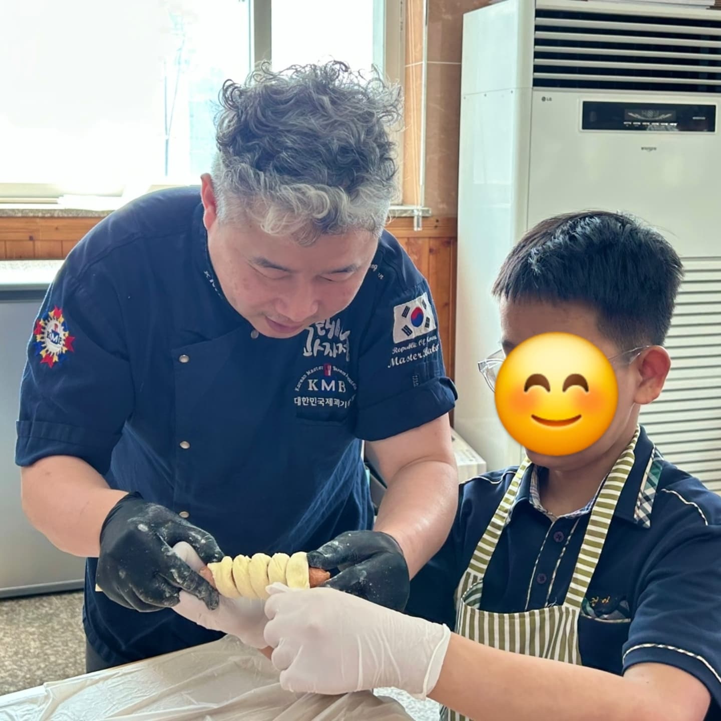 방과후교실 아이들을 도와 나무막대에 꽂힌 소세지에 밀가루 반죽을 감싸고 있는 모습입니다.