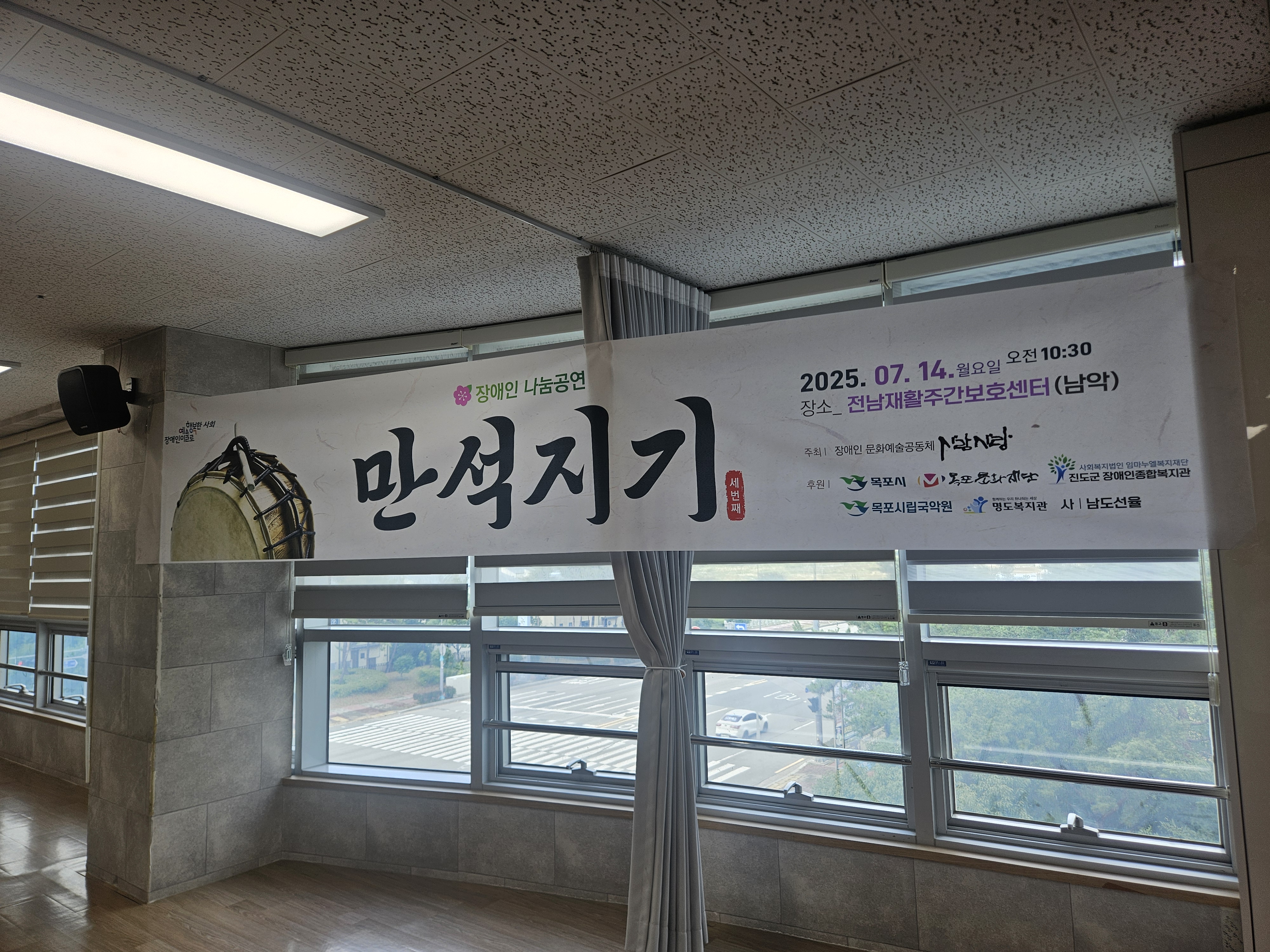장애인 나눔공연 만석지기. 라는 현수막이 걸려 있는 공간의 사진입니다. 