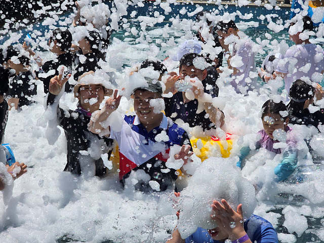 수영장에서 진행되는 버블쇼 프로그램에 주간보호센터 이용인들이 참여하여 거품을 묻히고 즐기는 모습입니다.