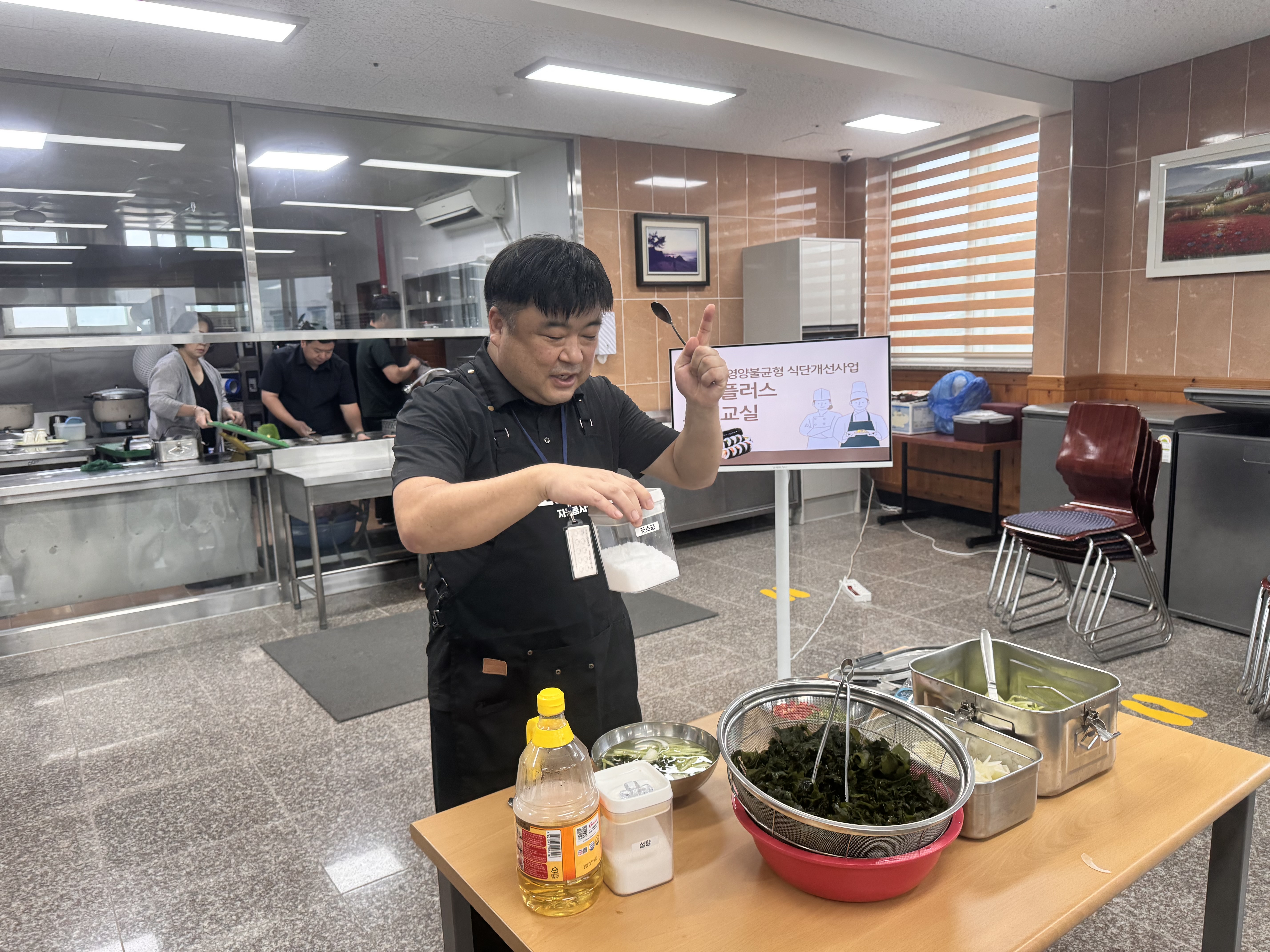 오이냉국을 만드는 방법을 설명하고 있는 담당자의 사진입니다. 