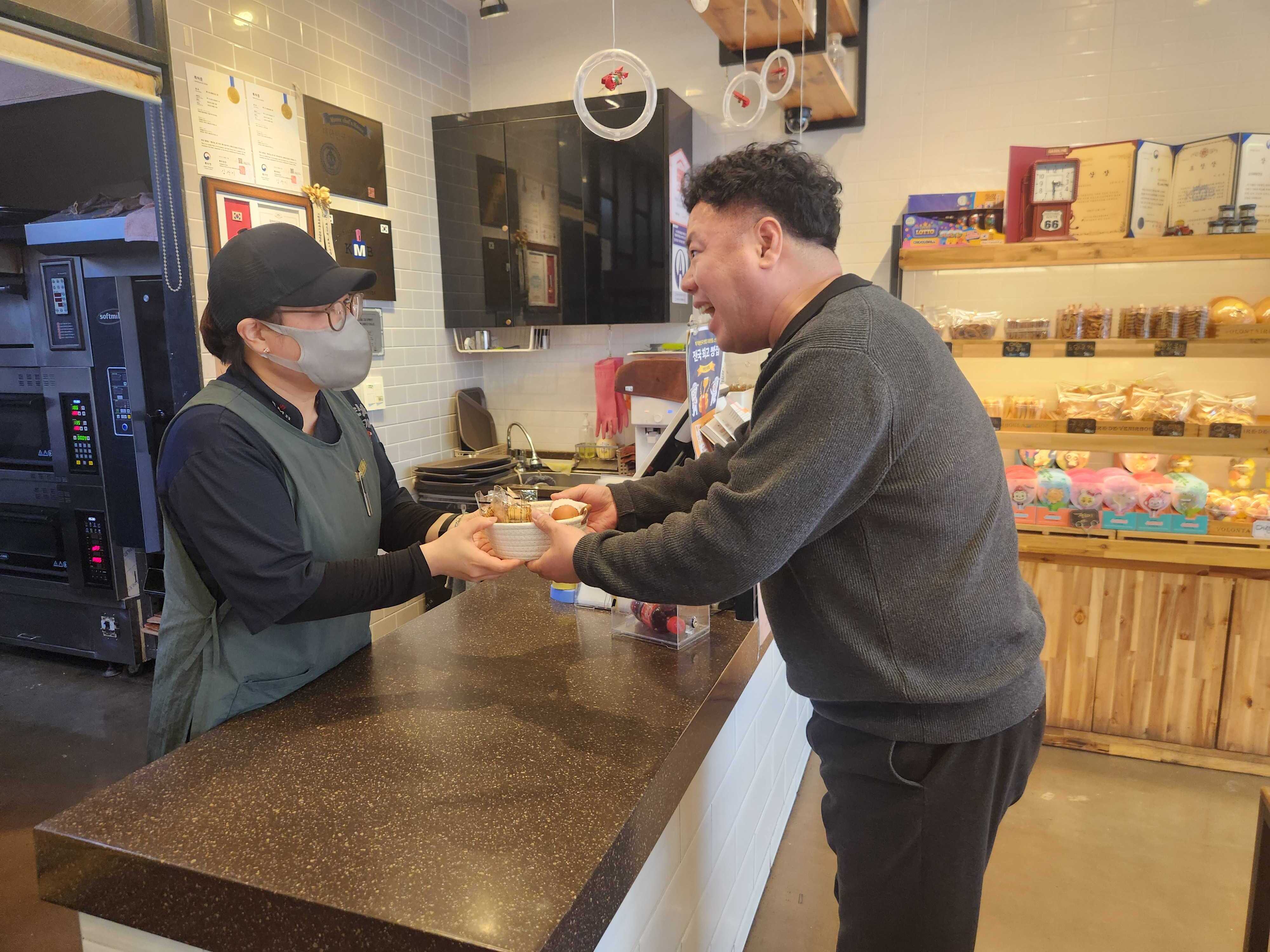 직원이 달걀바구니를 건네주고있는 모습입니다.