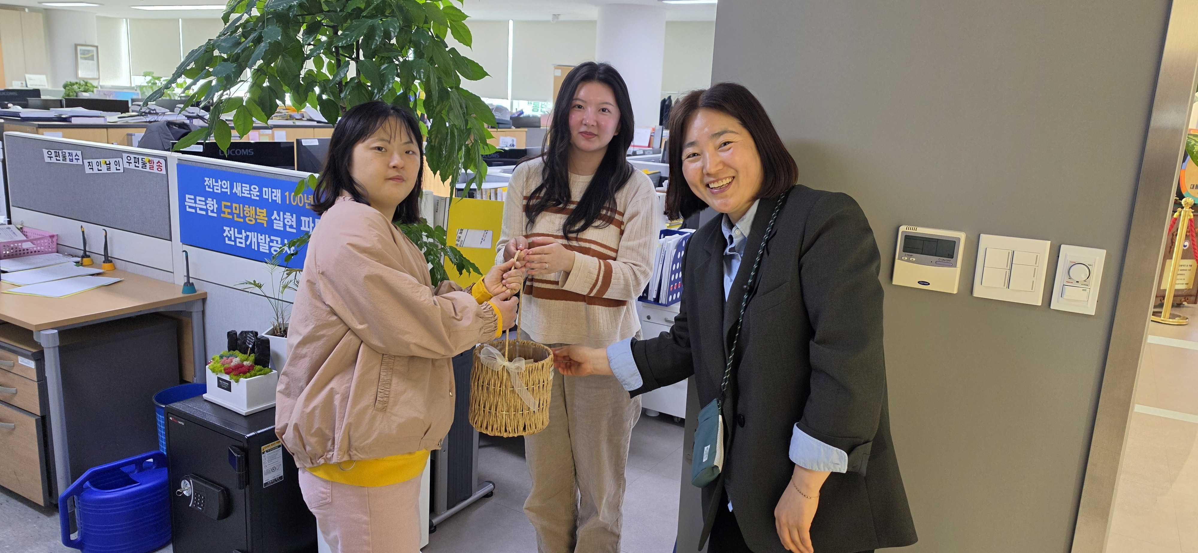 이용인과 담당직원이 달걀바구니를 건네주고있는 모습입니다.