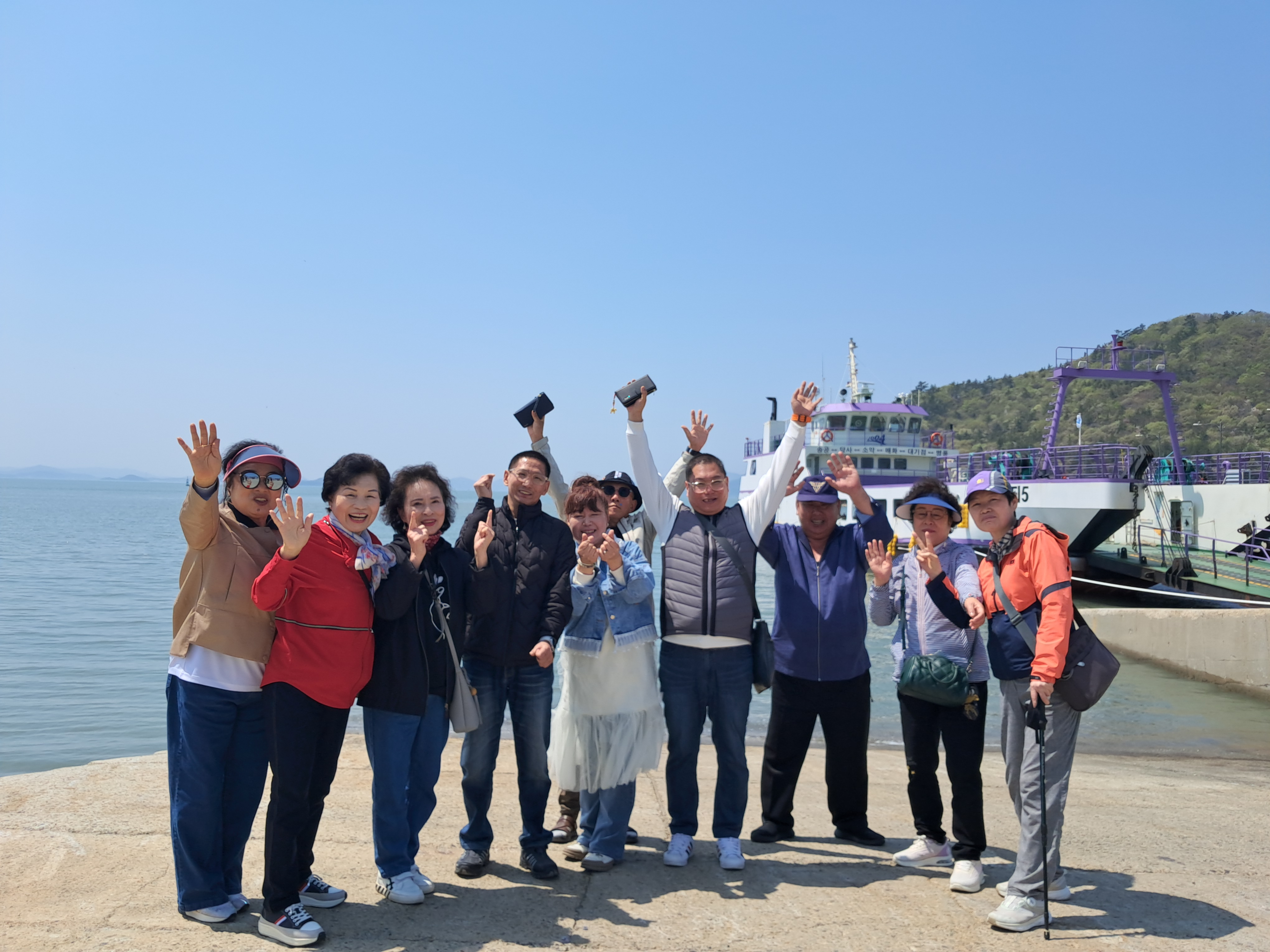 바닷가 앞에서 만세를 하며 사진을 찍는 모습입니다.