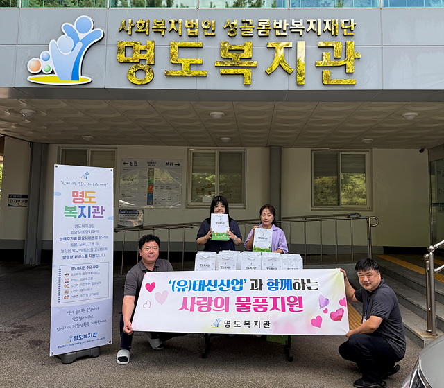 (유)태신산업의 현수막과 반찬들을 들고 찍은 사진입니다.